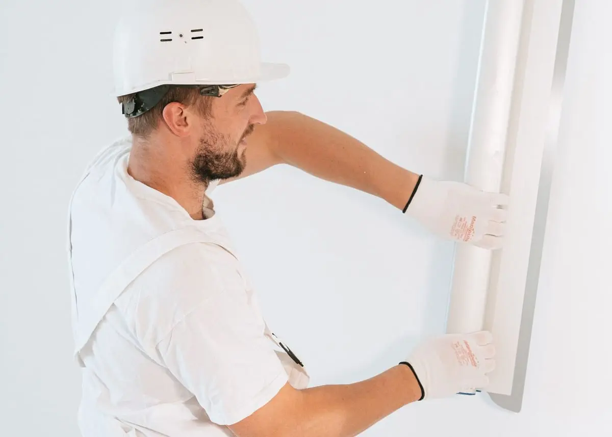 Professional installing drywall panels inside a residential space